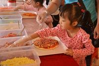 一小孩正在DIY自己的披萨