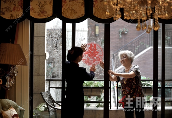 金科服务工作人员与老人一起贴窗花.png
